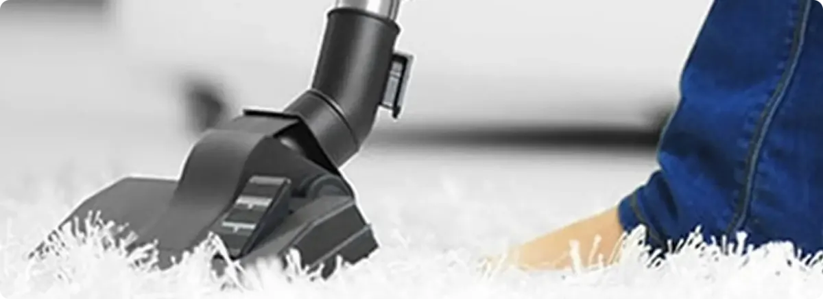 Close-up of a professional vacuuming a white carpet in Hamden.