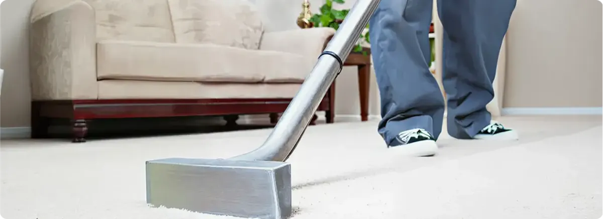 Carpet cleaning technician using a hot-water extraction wand on a light-colored carpet in a living room, New Haven, CT.
